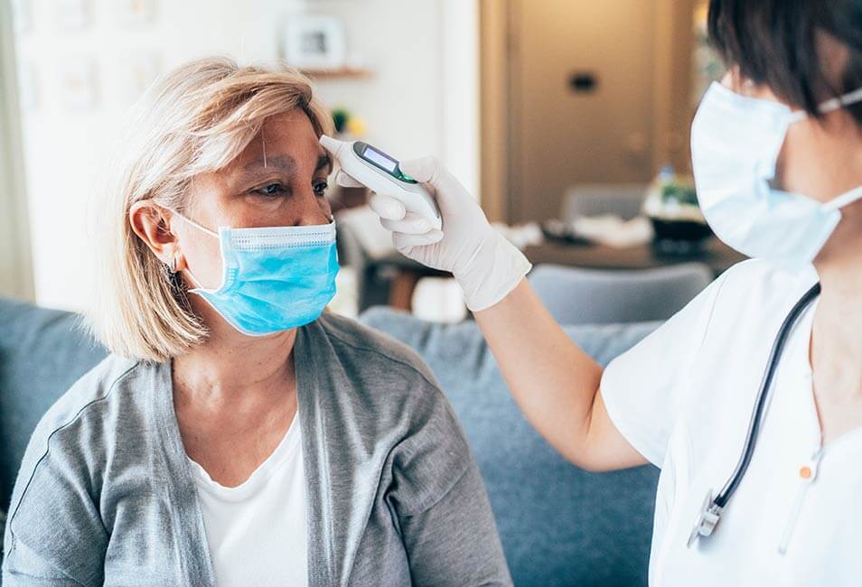 caregiver taking temperature of a resident