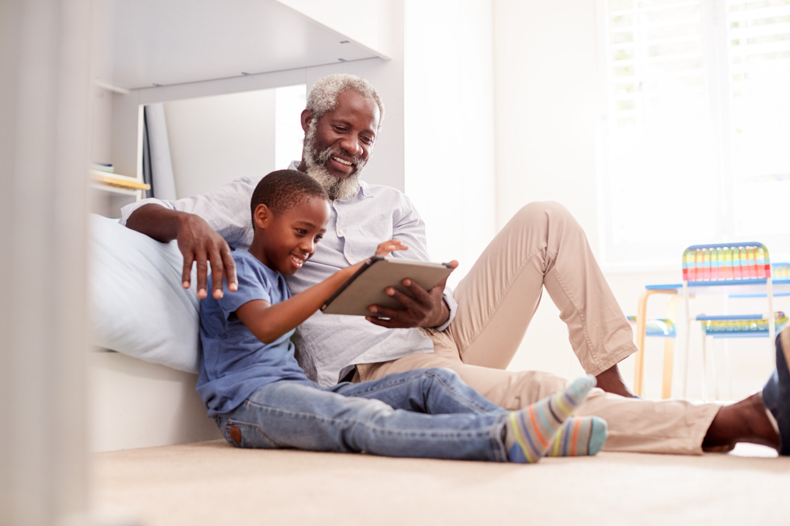 A grandfather reading with his grandson to help keep his mind sharp.