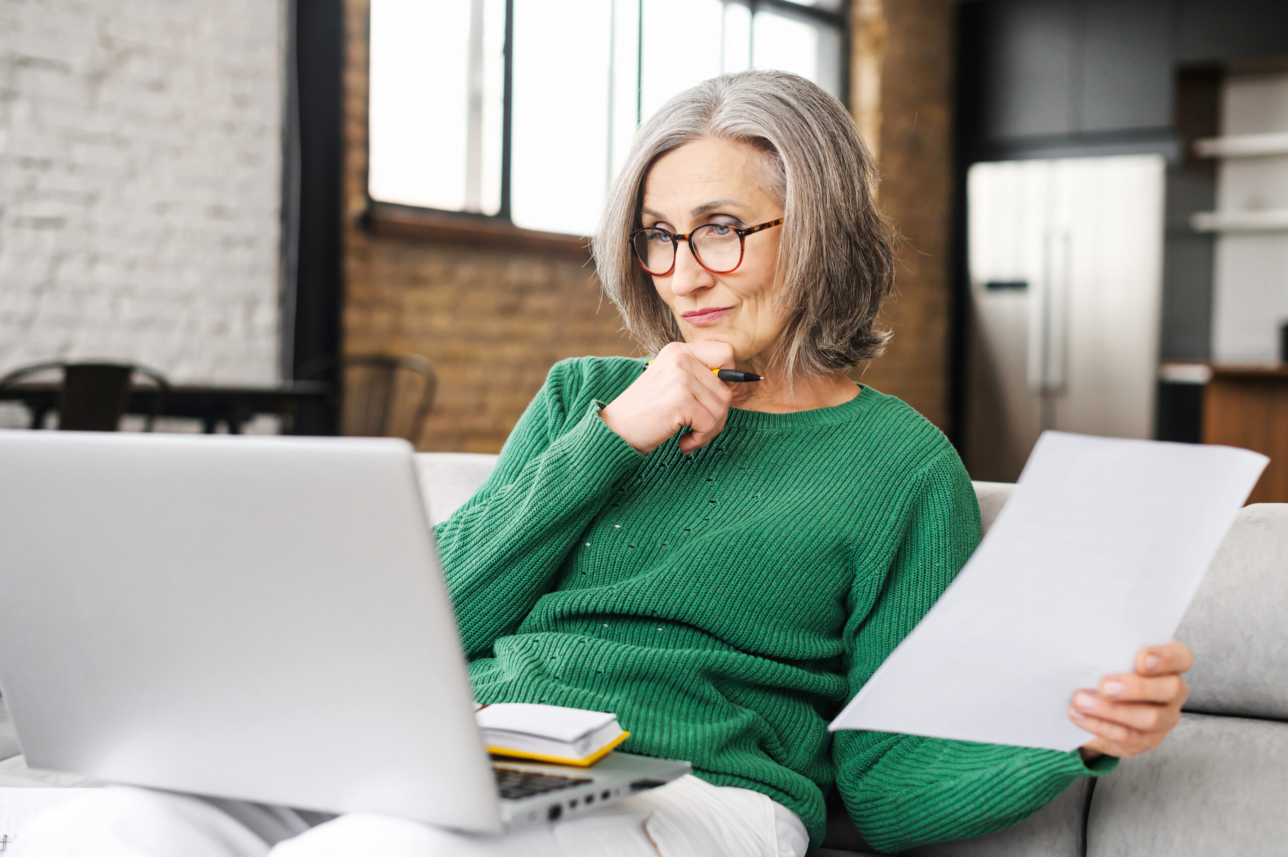 An elderly woman researching and reviewing legal documents for seniors