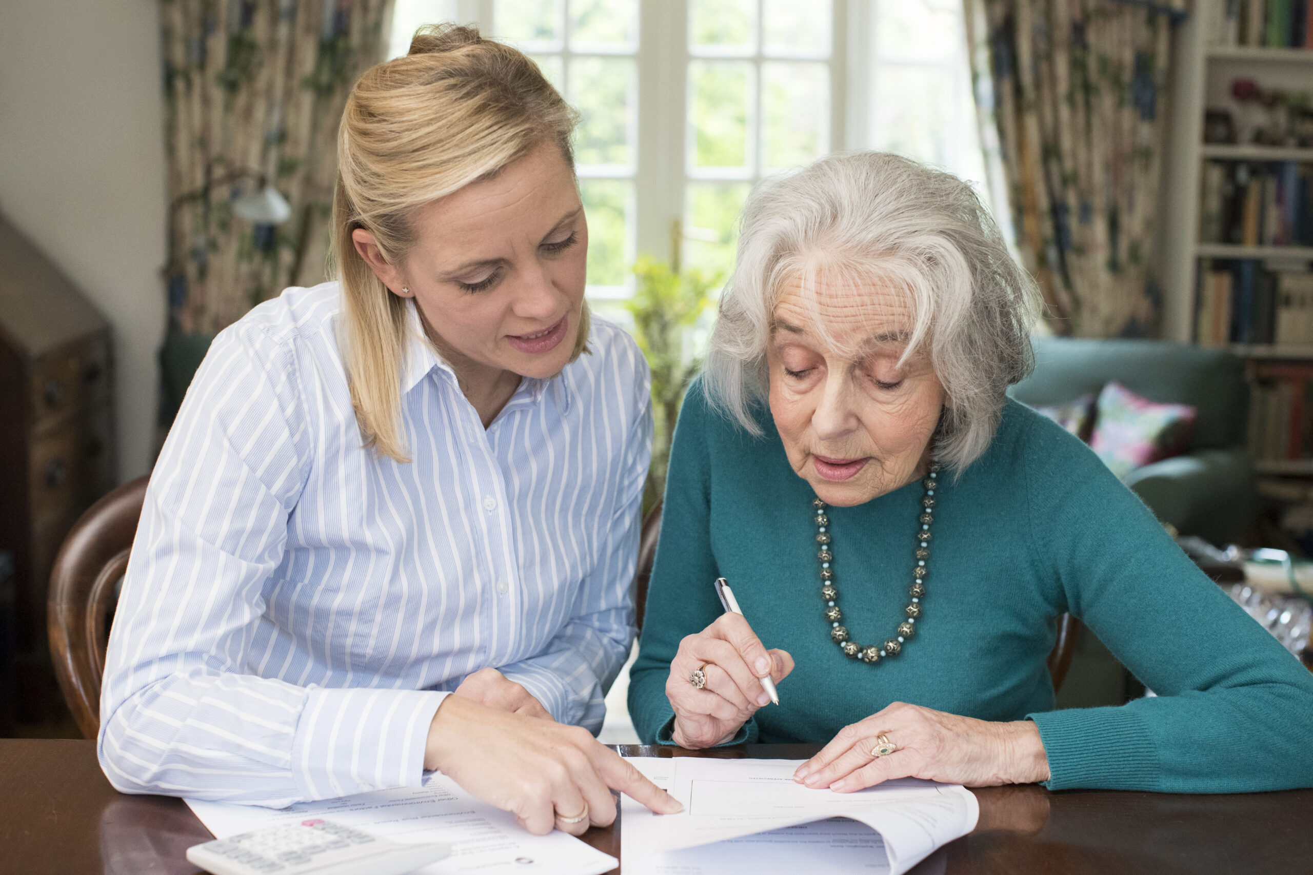 An elderly parent signing a power of attorney form.