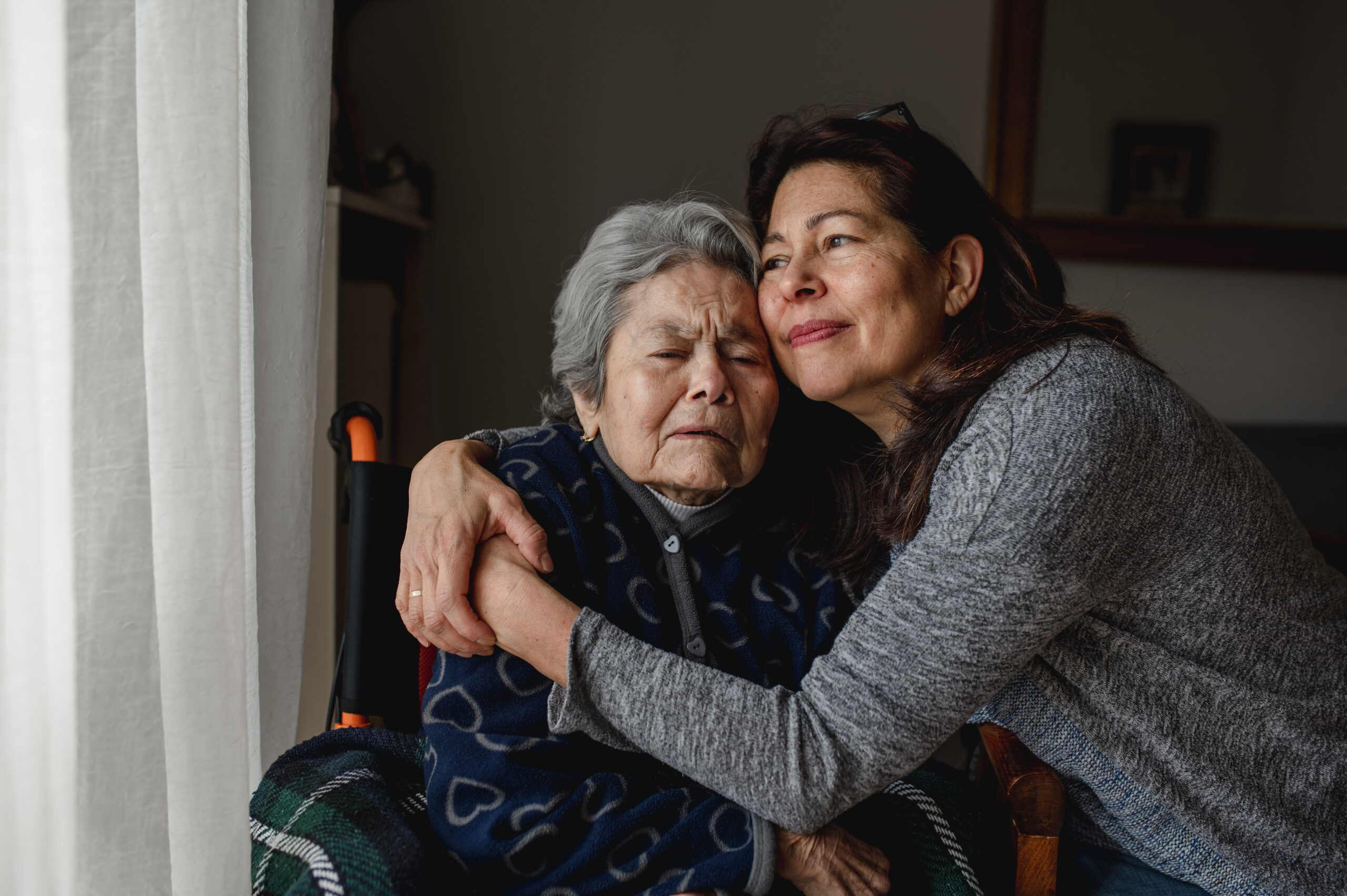 A happy woman holding her mother after taking steps to alleviate caregiver burnout and stress.