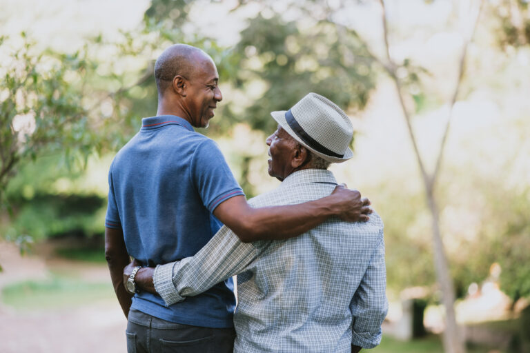 Father and son hug while discussing assisted living vs nursing home