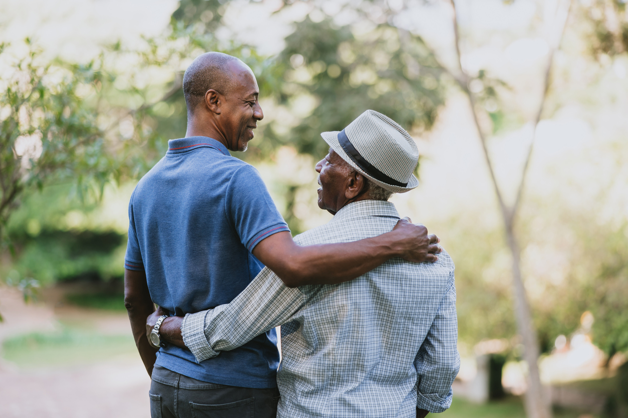 Father and son hug while discussing assisted living vs nursing home