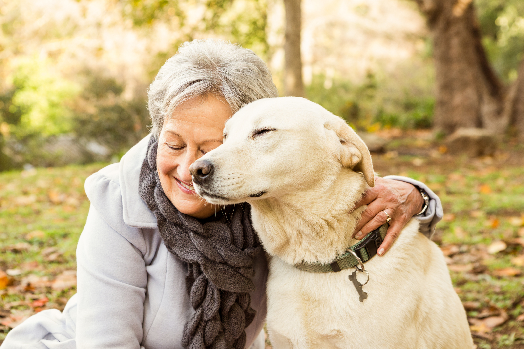 An older woman enjoying snuggles with her dog – one of the many benefits of pets for seniors.