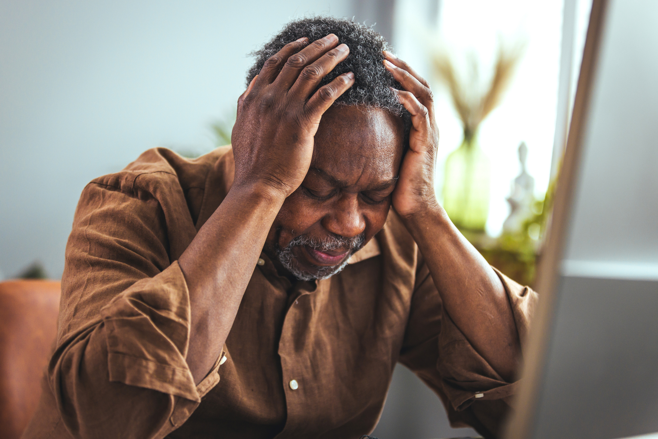 An elderly man shrugs in frustration from having to deal with elder fraud.