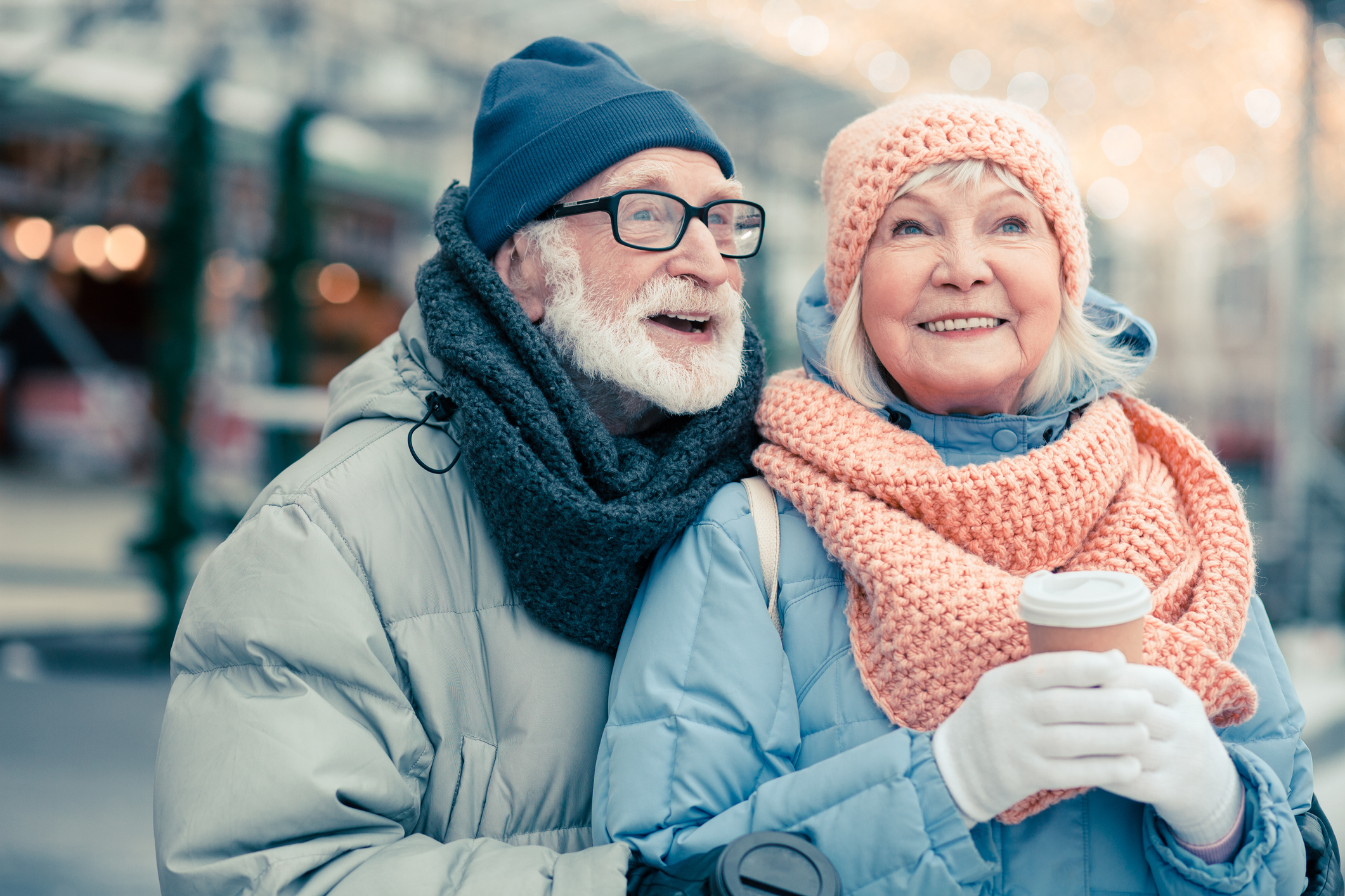 A senior couple following cold weather safety tips as they share a moment in the winter snow.
