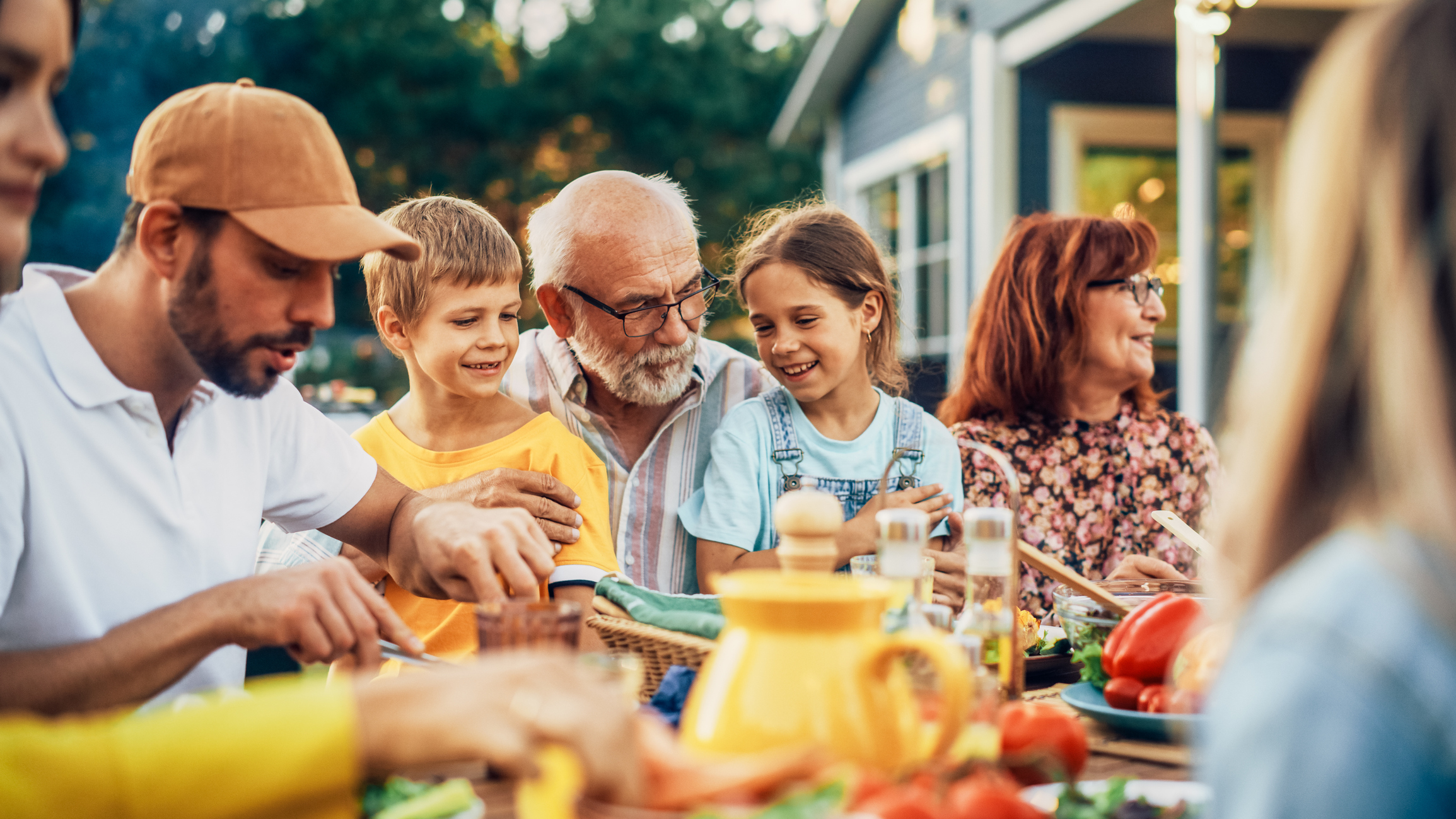 A senior man creating memories with family members at a picnic.