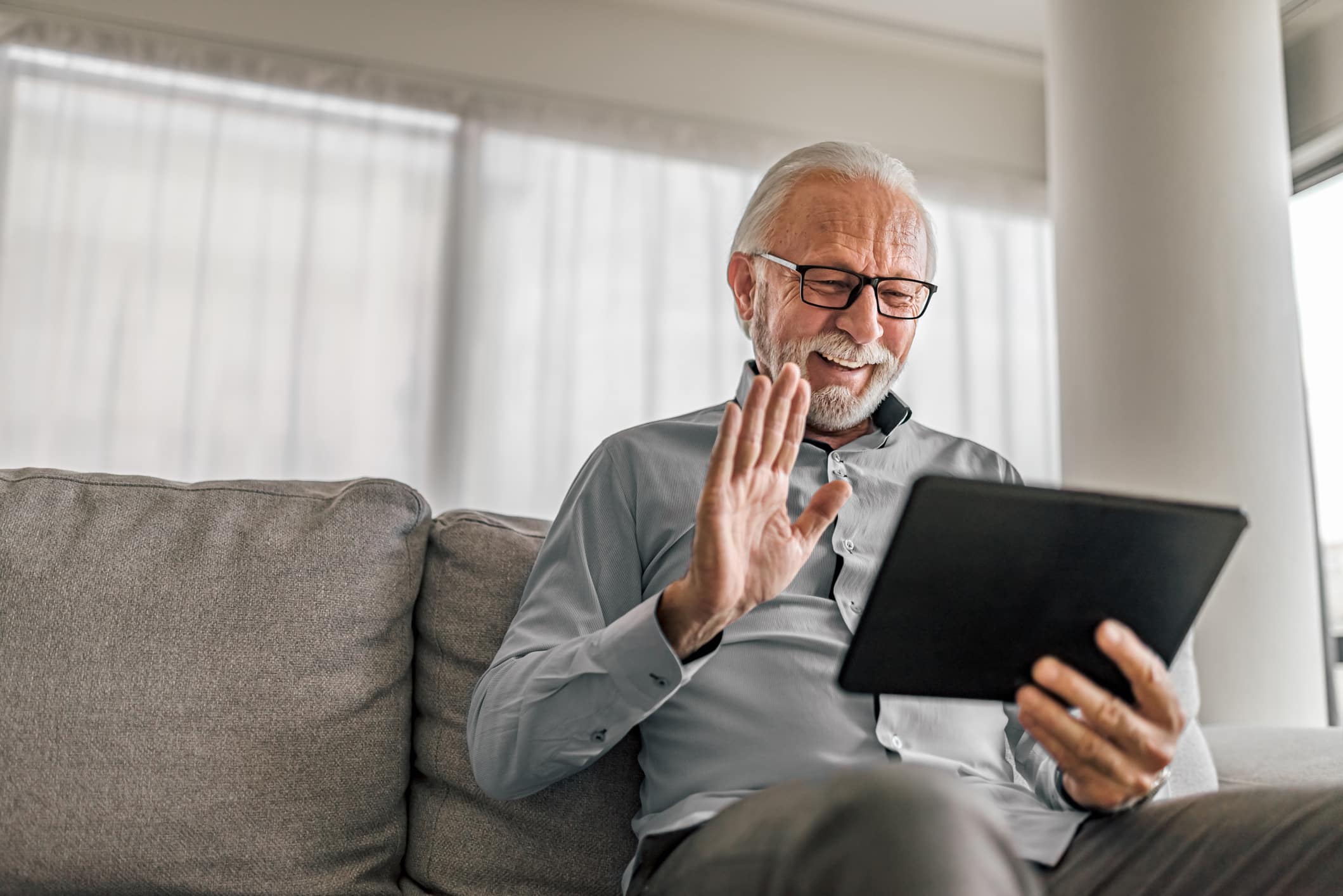 An older adult using digital technology for seniors to connect with loved ones.