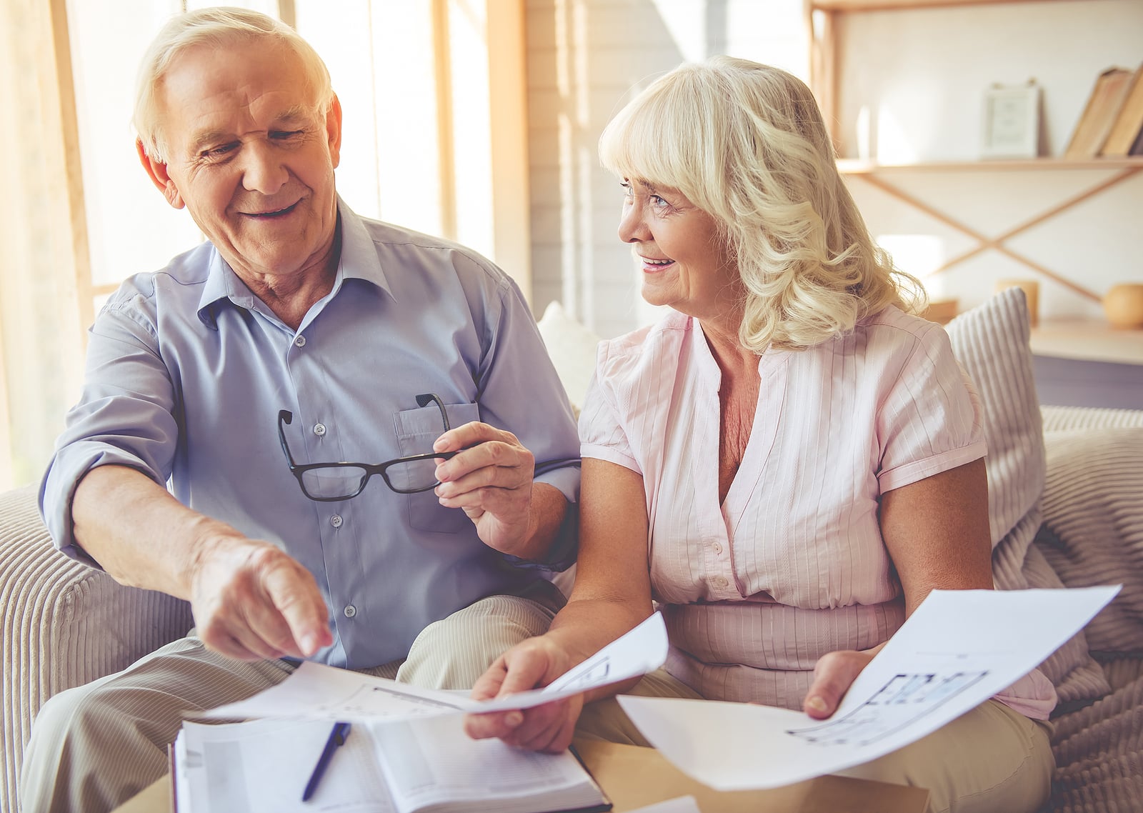 An older couple looks over floor plans together, imagining their future in a senior living community.