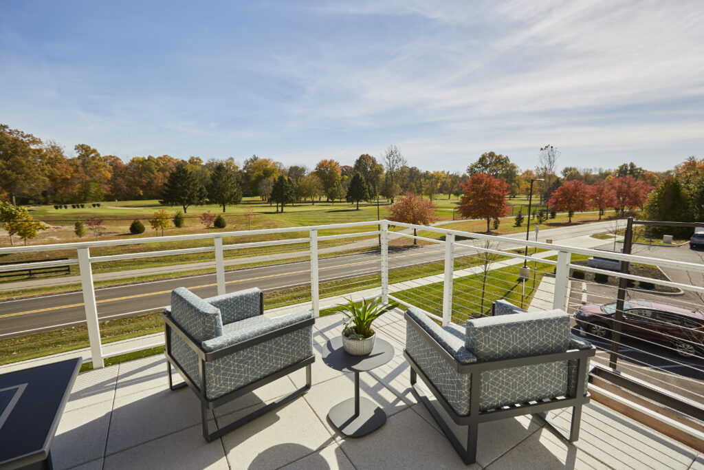 Rooftop patio with two chairs and a view