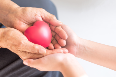 senior hands holding a heart shaped stress ball