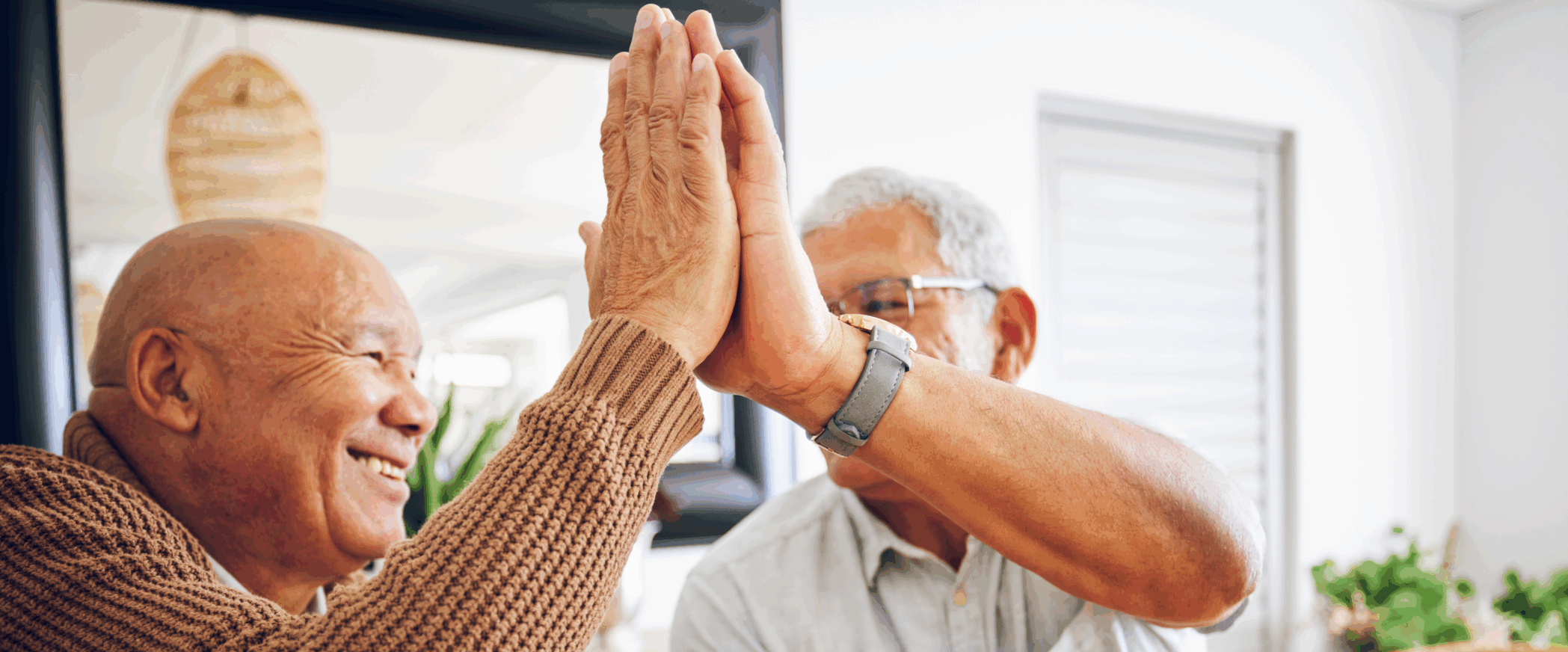 two senior men high fiving each other