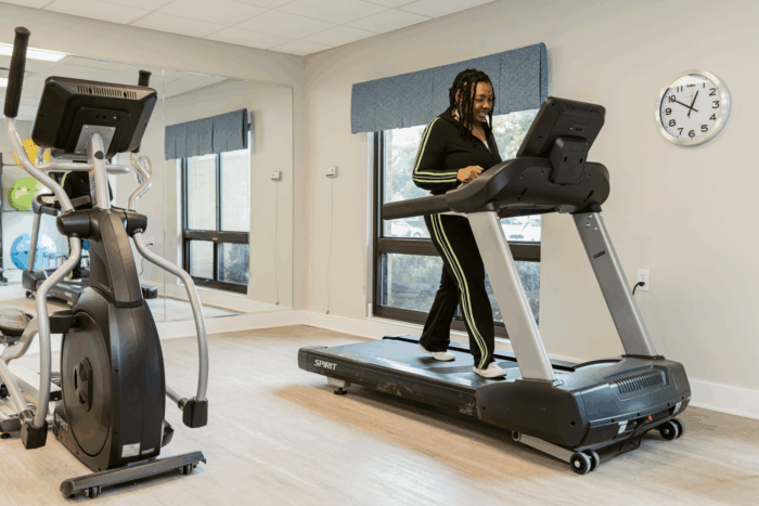 Woman walking on treadmill in fitness room