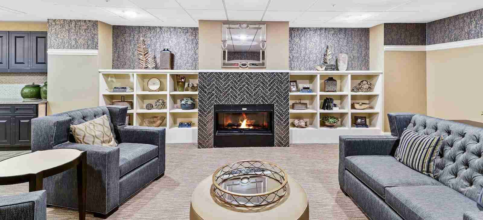 Lounge area with fireplace, bookshelves, and comfortable seating