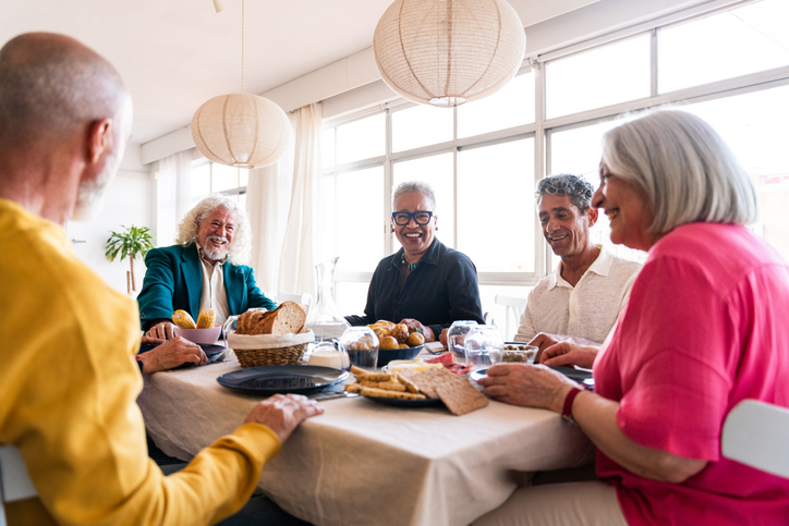 Seniors laughing together at a dining table