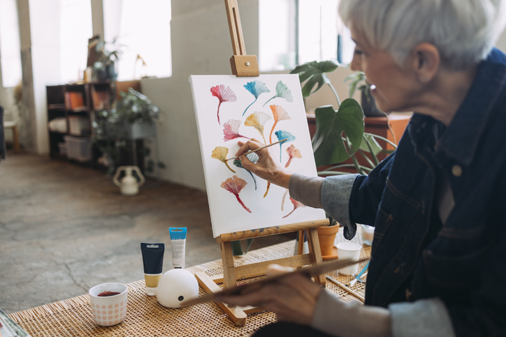 Senior woman painting on an easel