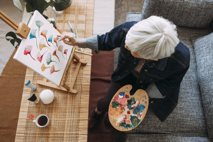 Senior woman painting in the creative arts studio at Brookwood Point