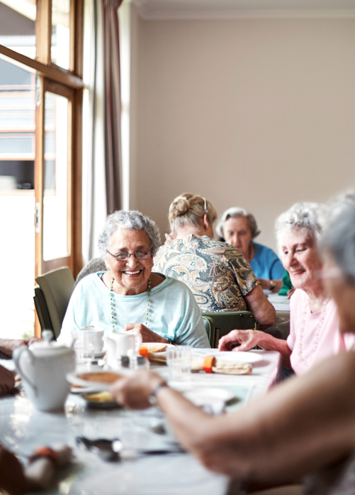 Seniors laughing and dining together at Brookwood Point