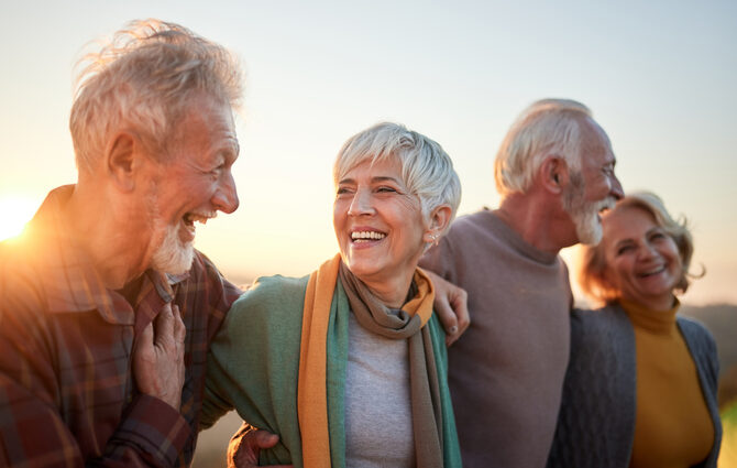 Happy senior couples smiling while walking in at sunset