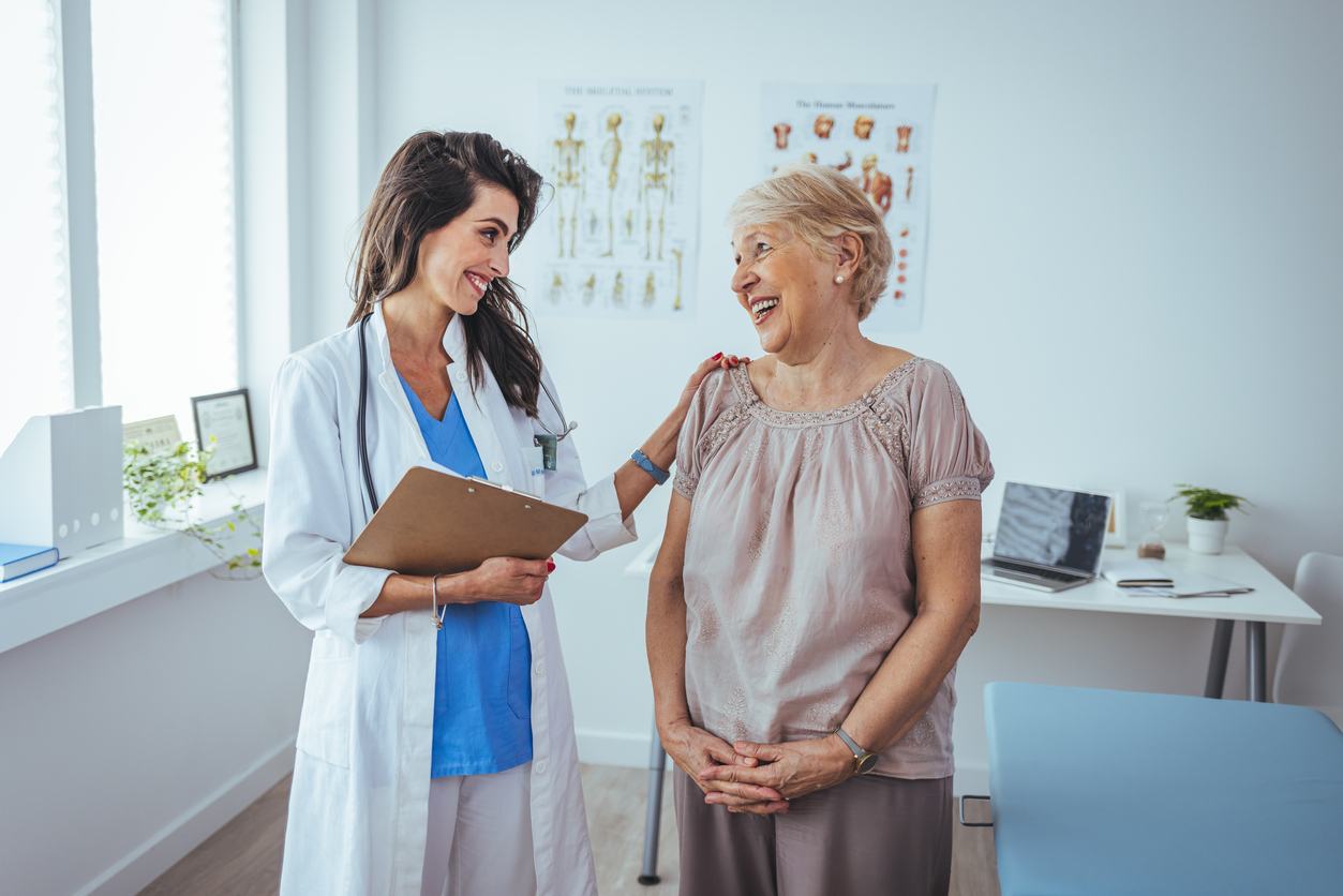Doctor smiling at a happy senior woman in an examination room