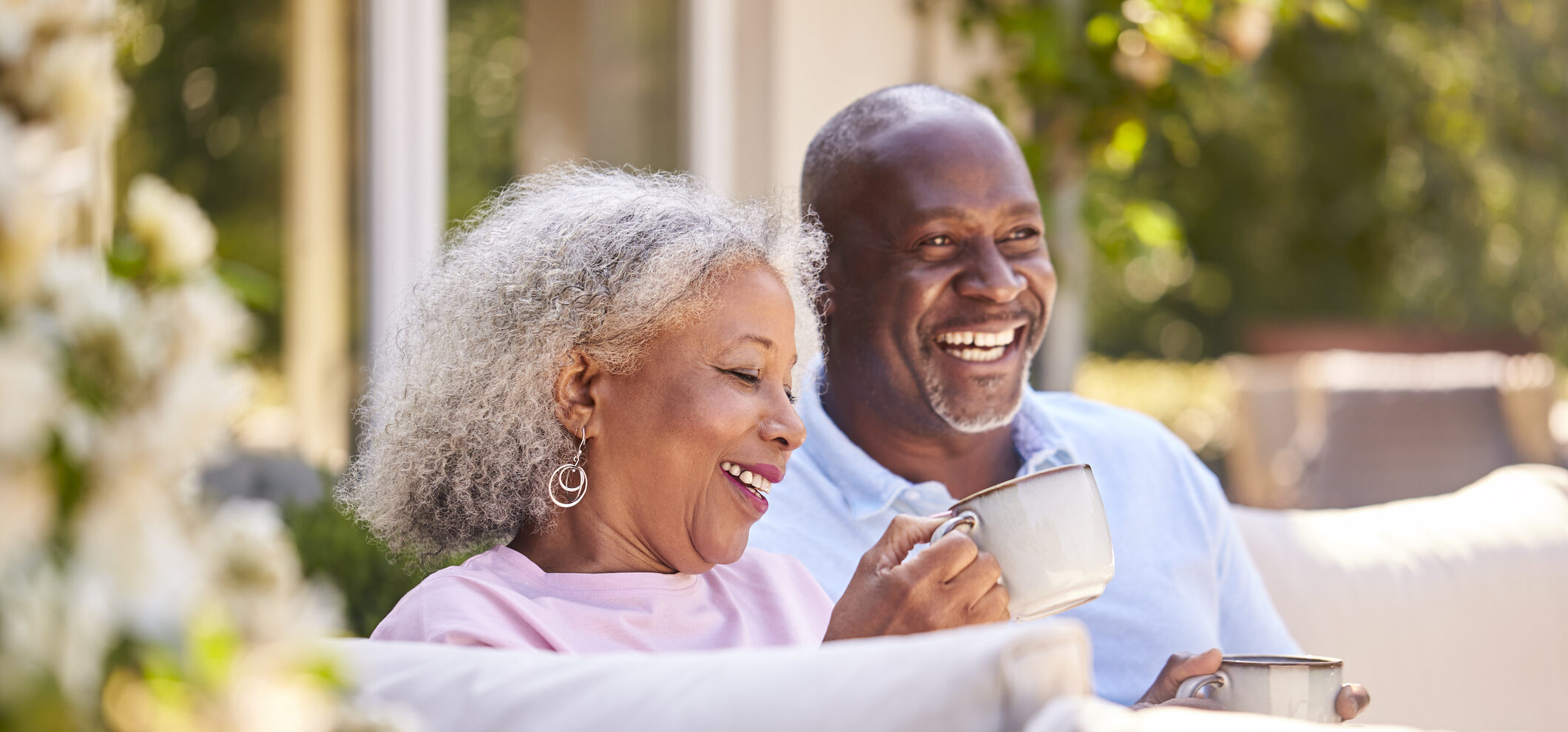 Happy senior couple enjoying coffee on the patio at Brookwood Point