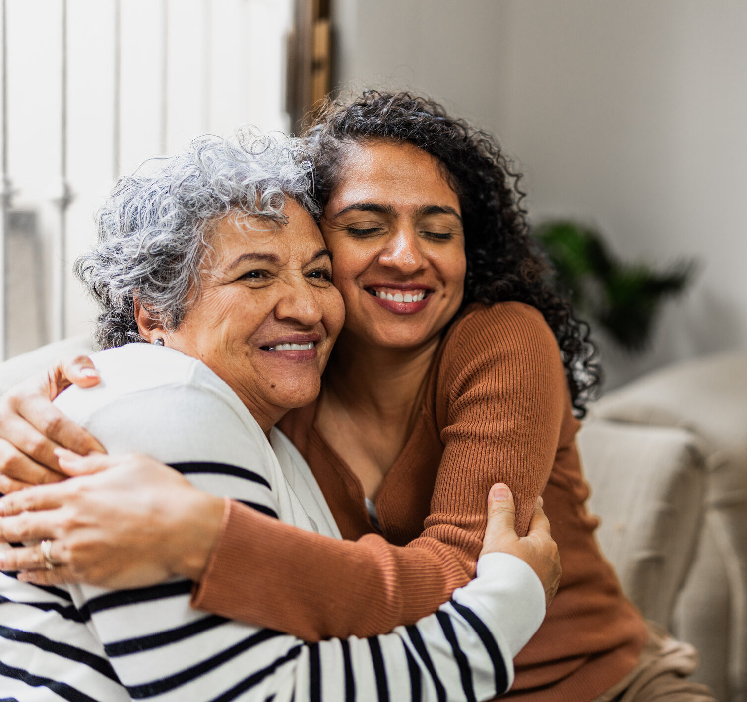 Senior woman embracing her daughter with a warm smile