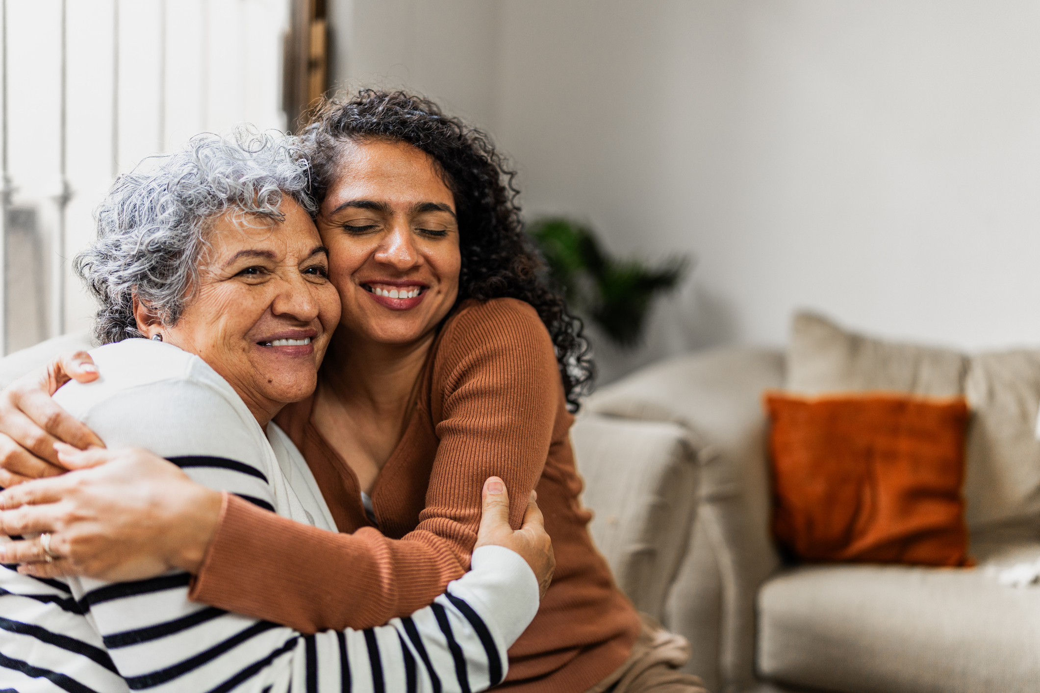 Senior woman embracing her daughter with a warm smile