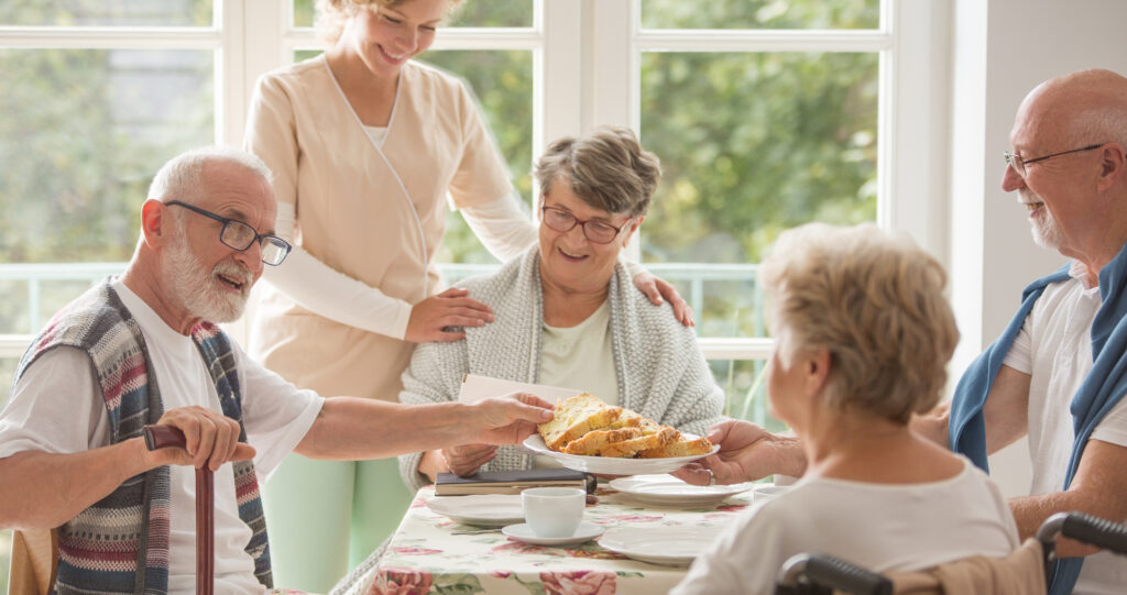 Caregiver serving breakfast to seniors