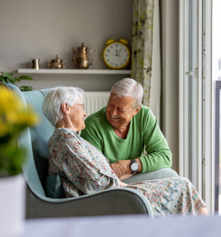 Senior couple smiling and talking in a bright, modern living room