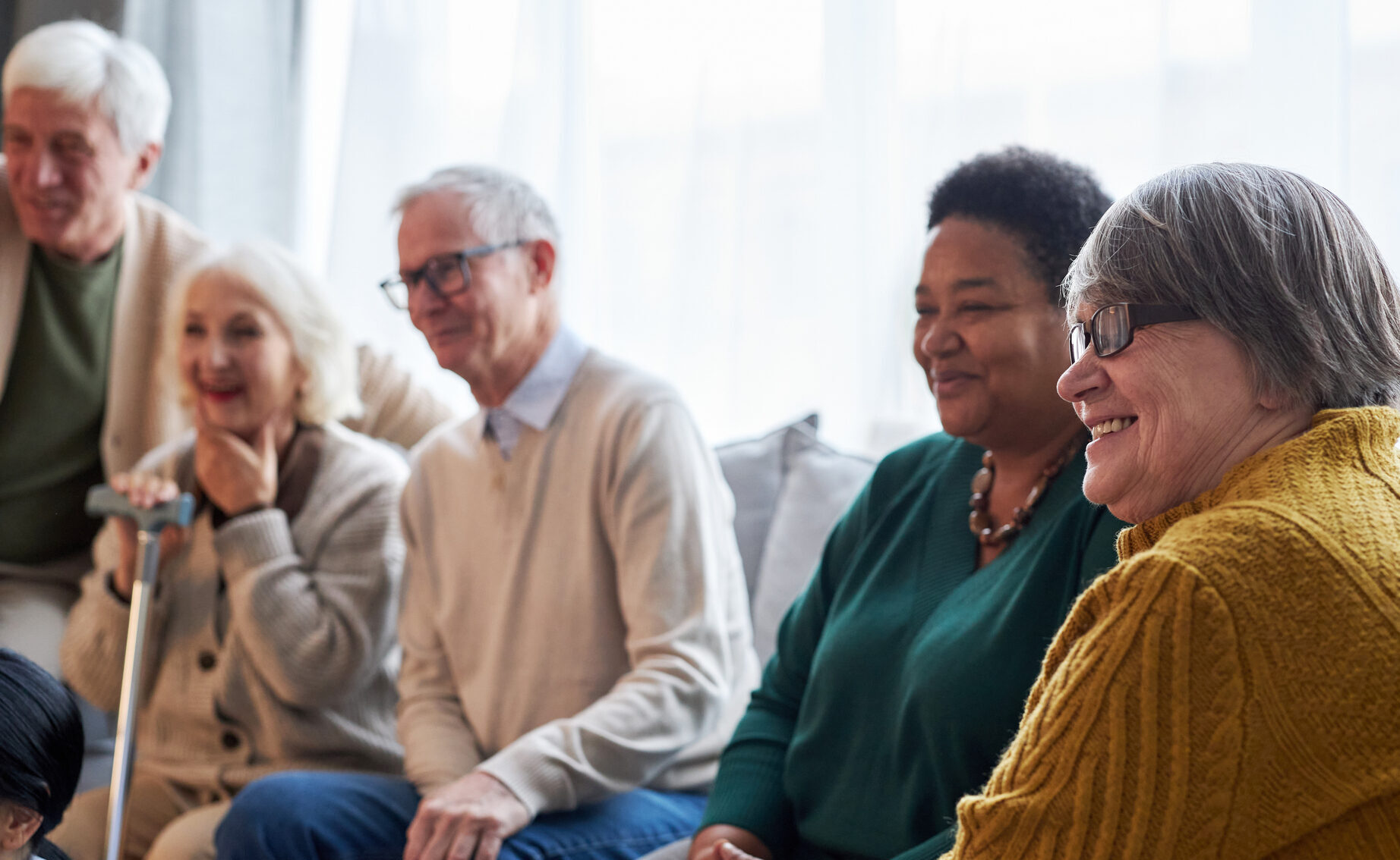 Diverse group of smiling seniors sitting together in a community setting