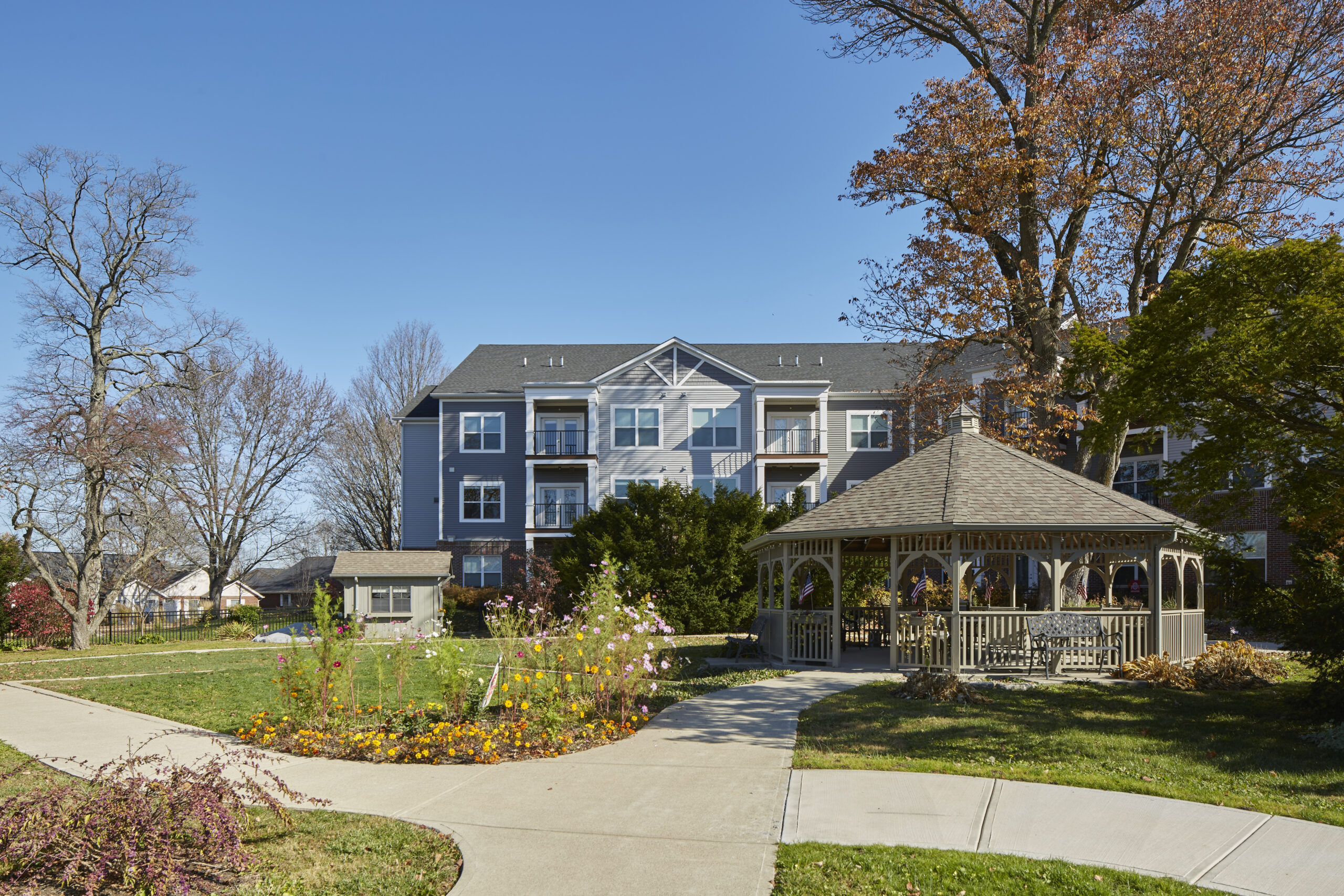 Exterior view of a senior living community building and a gazebo