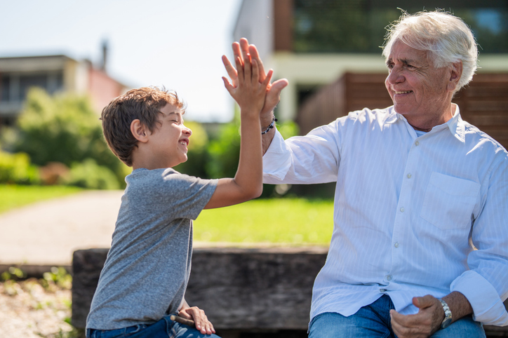 Senior high fiving his grandson