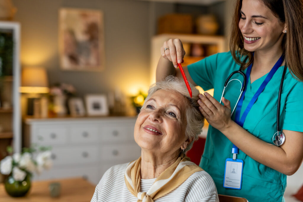 Caregiver combing a senior woman's hair