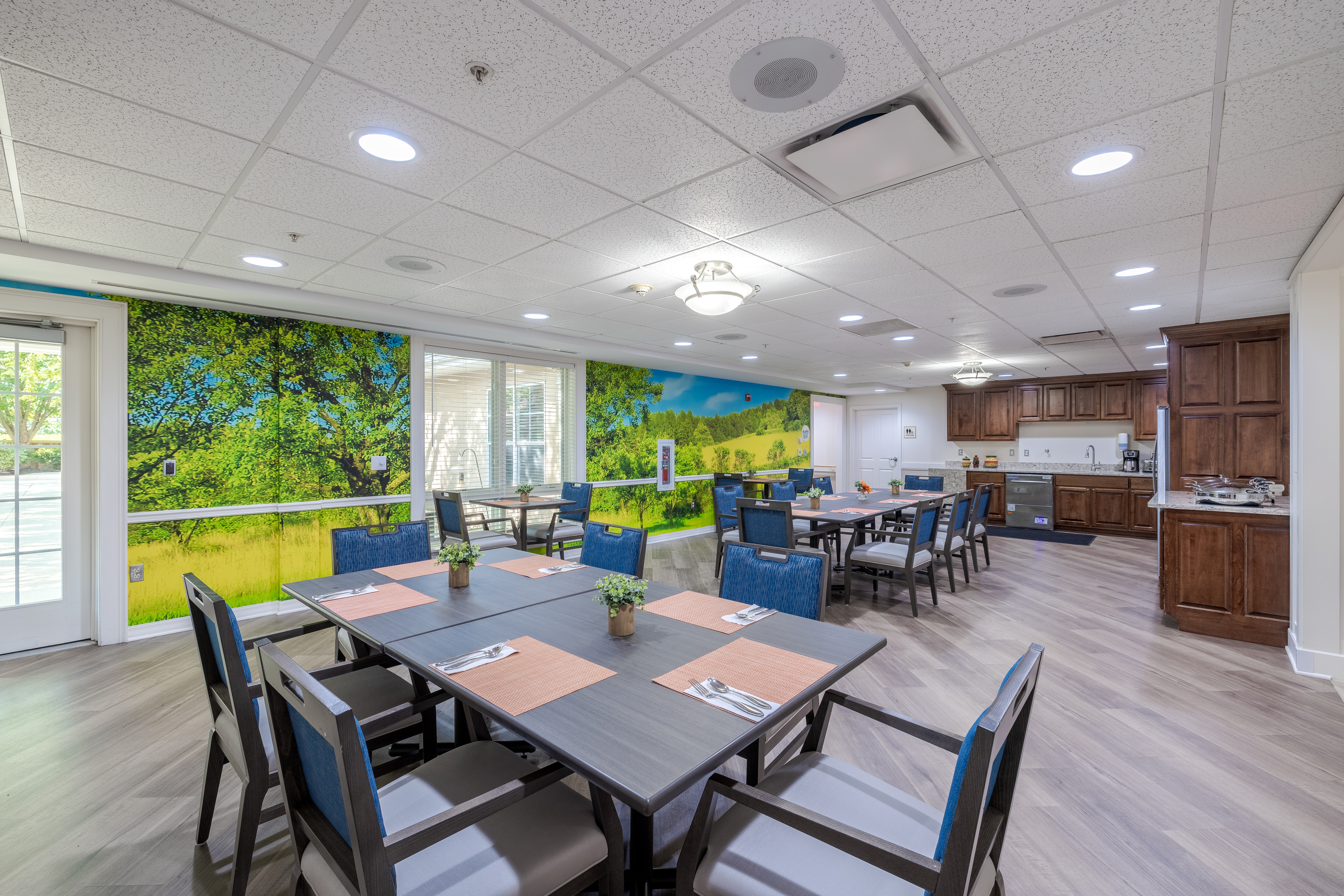 Dining room with a nature mural and tables set for a meal