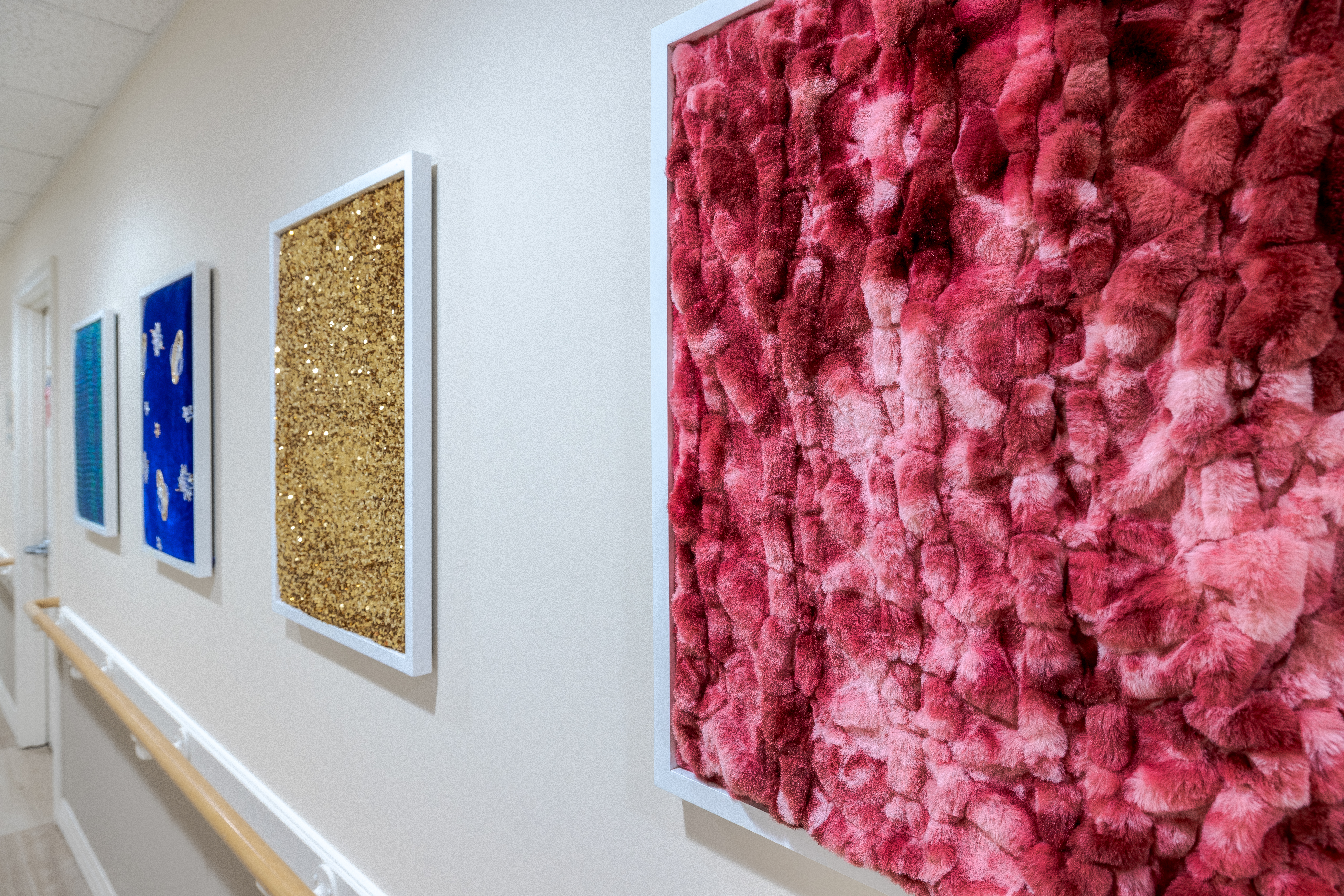 Hallway with decorative, textured art pieces on the wall