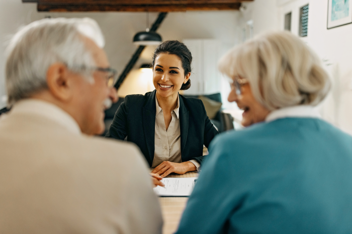 two seniors sitting at a table with a sales woman