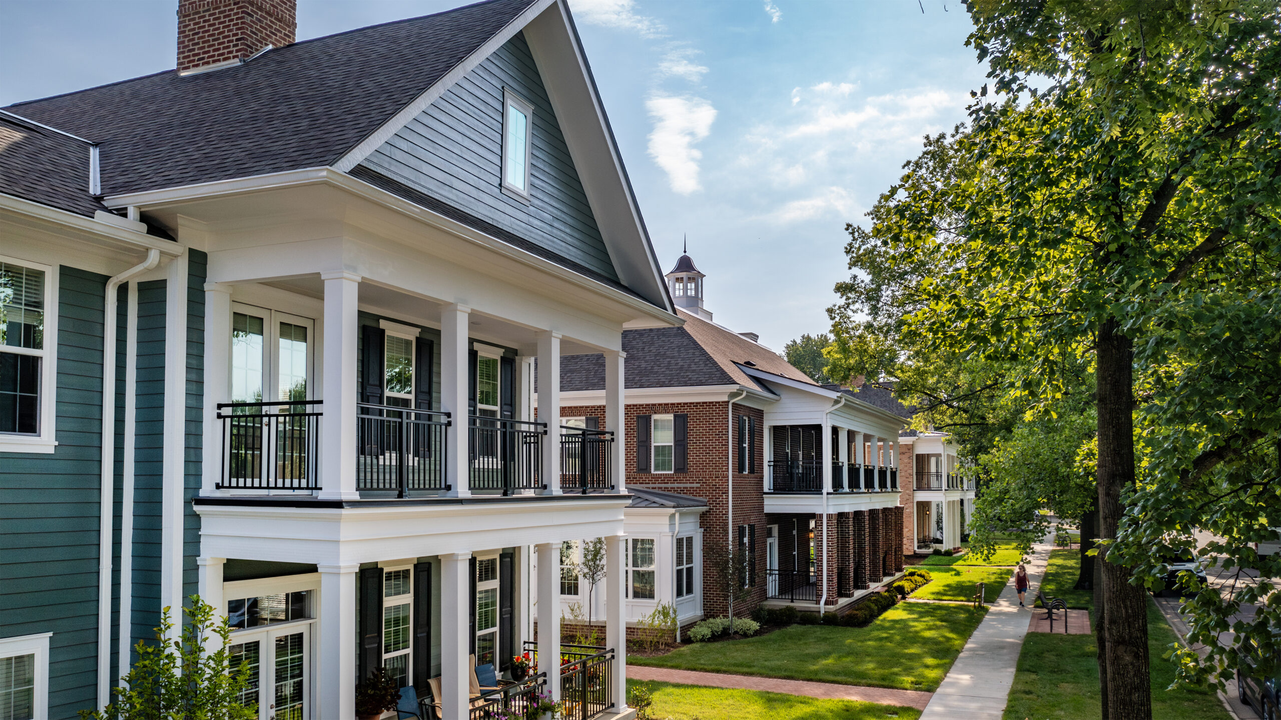 Tree-lined street view of a residential community with townhouses
