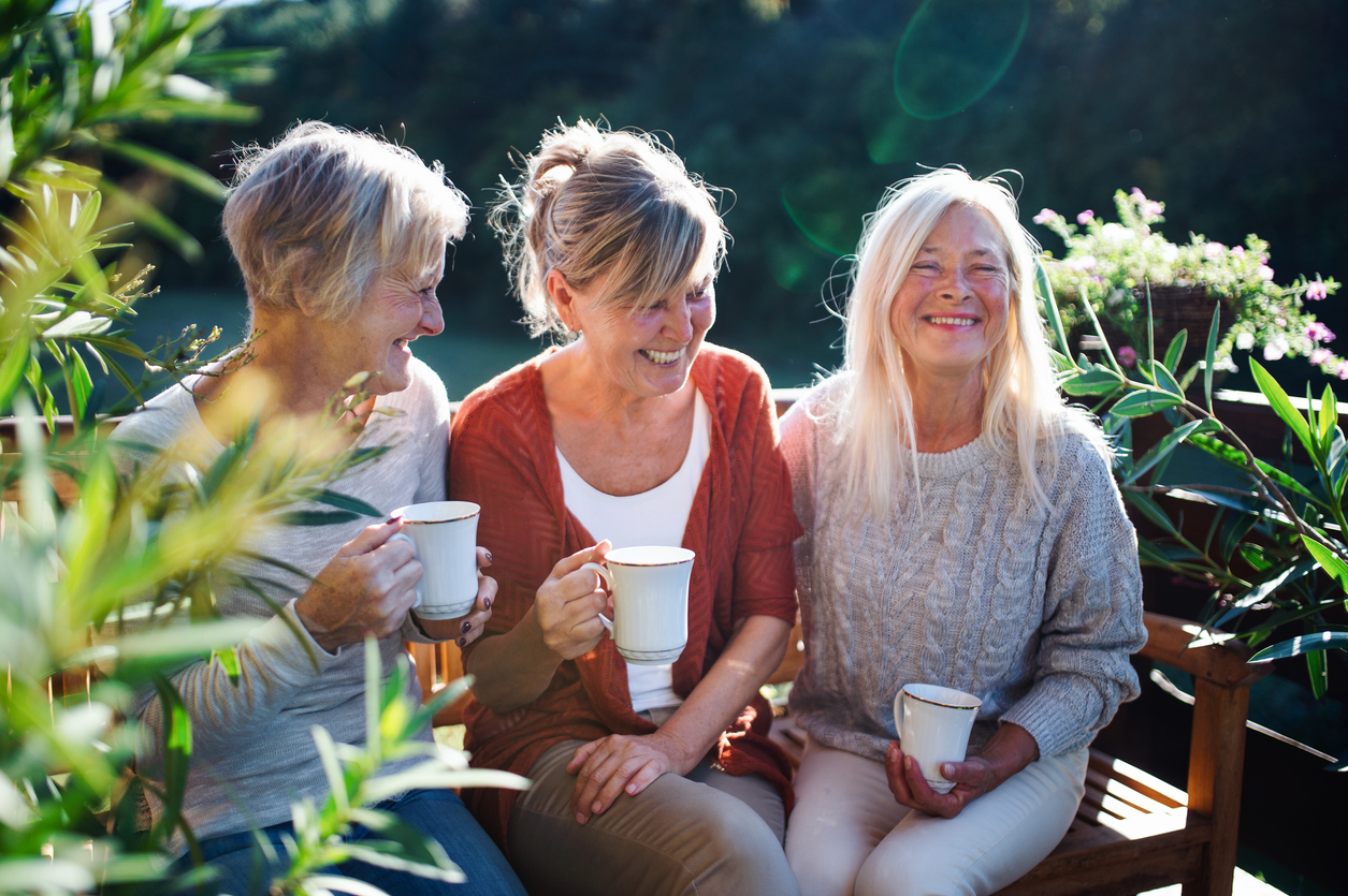 Senior friends having coffee on patio