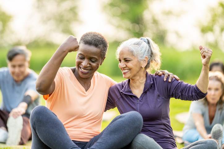 Seniors flexing muscles at yoga class