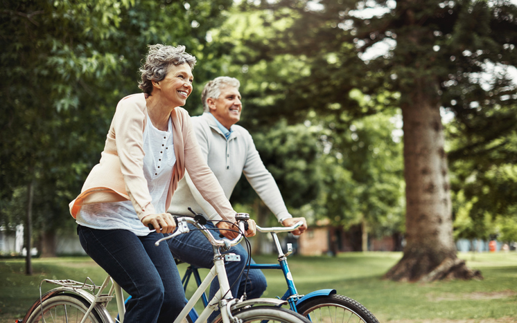 Active seniors riding bicycles through the park