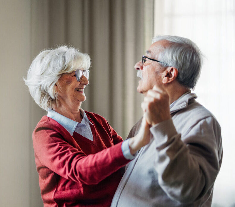 Senior couple dancing happily in a bright room