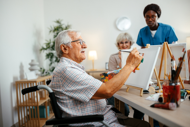 Senior man painting in a wheelchair
