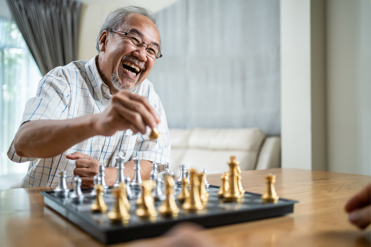 senior man sitting down and playing chess