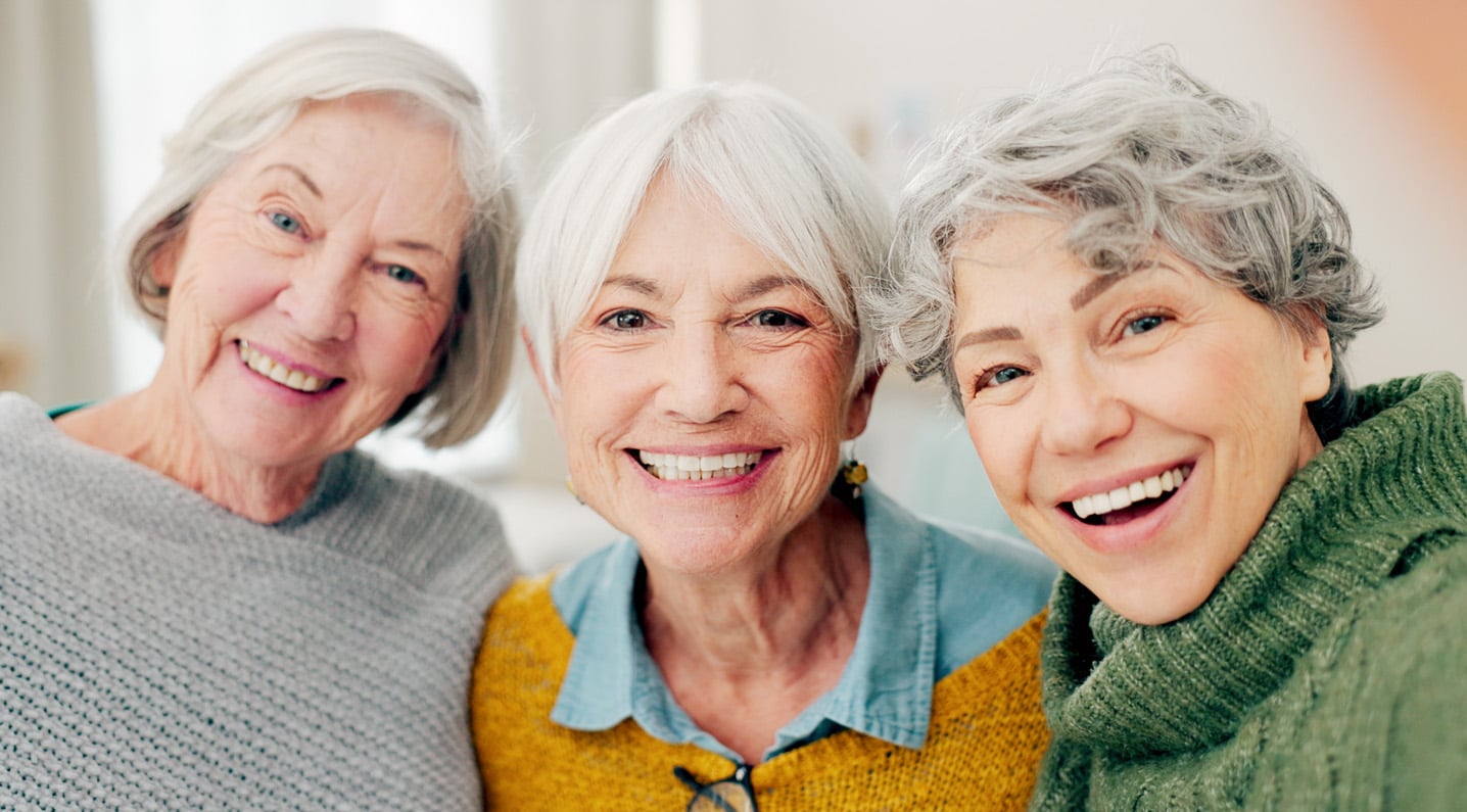 3 senior women smiling at camera