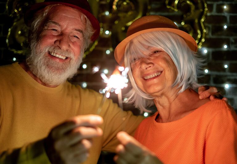 Senior man and woman celebrating the new year with sparklers