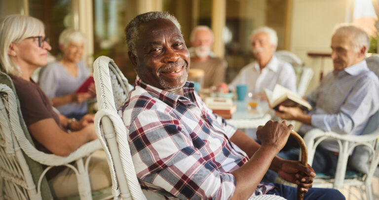 Senior man enjoying time with friends at his assisted living community