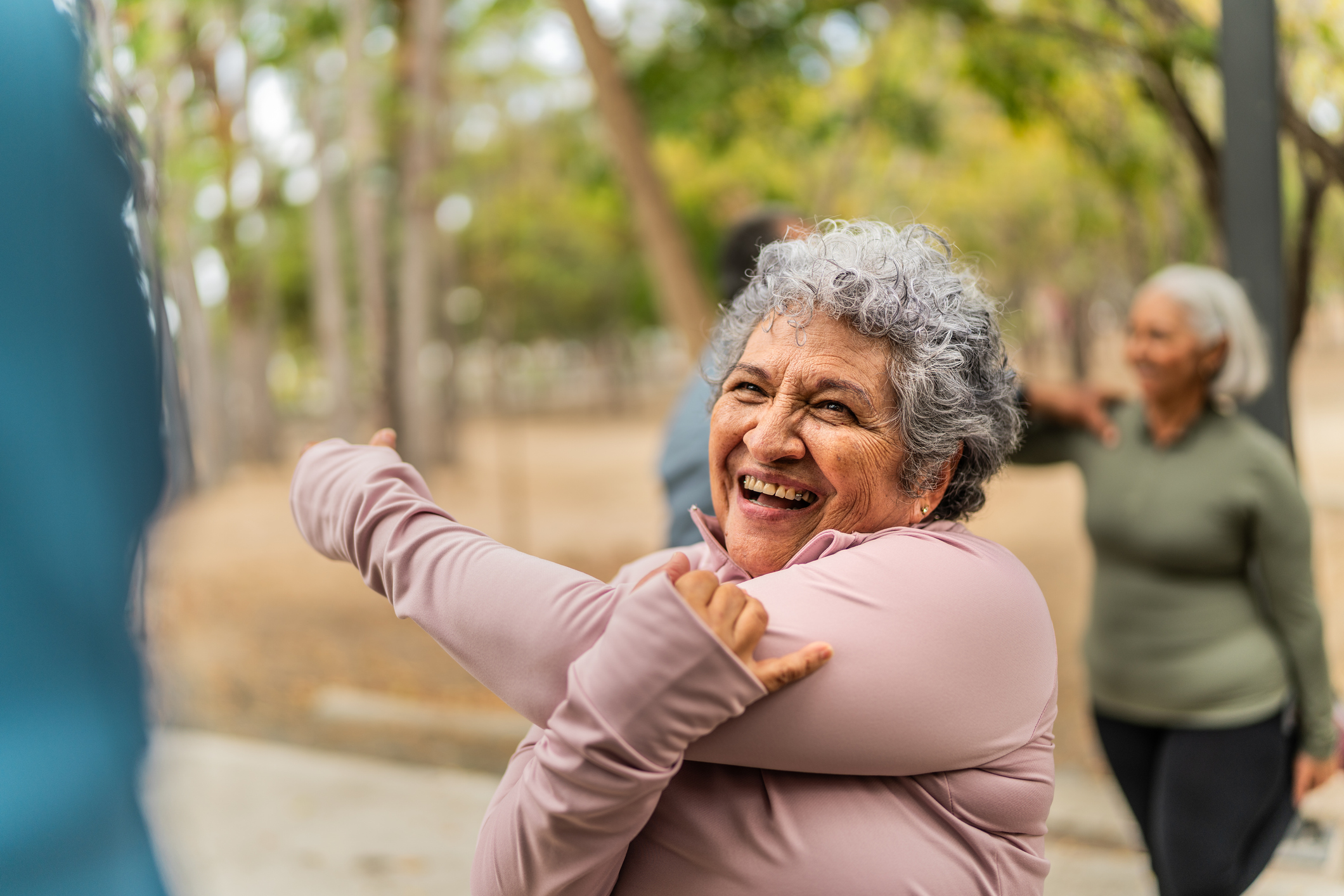 Senior woman stretching and smiling outdoors