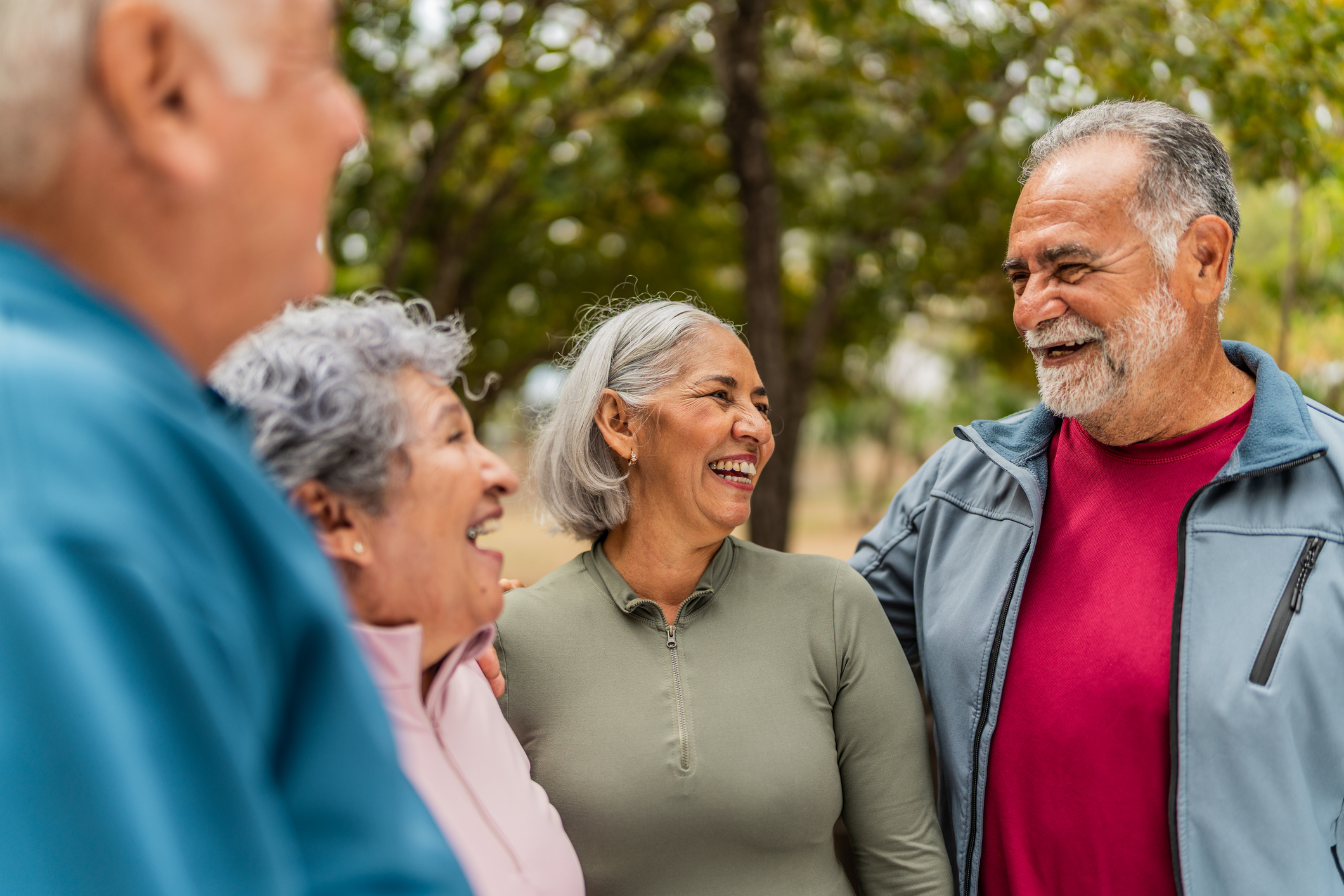 Senior friends talking outdoors and smiling