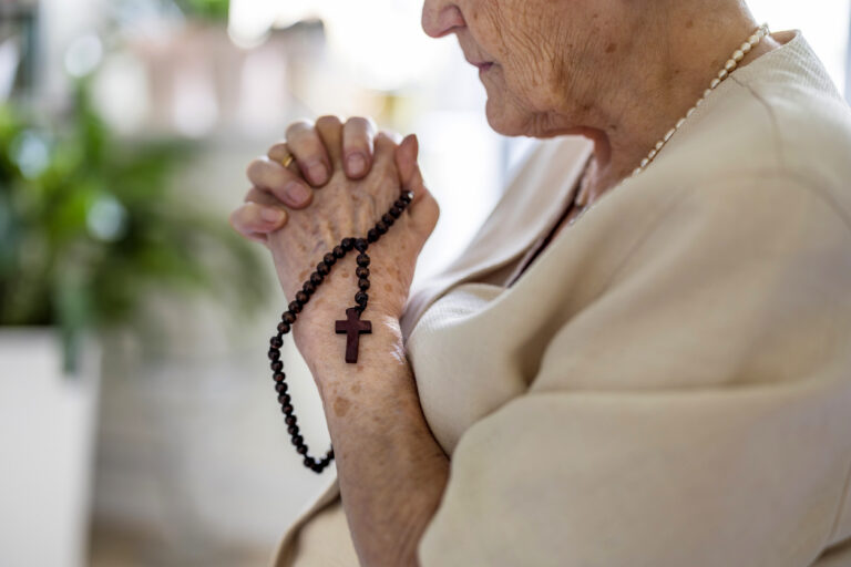 Senior woman praying in a faith-based senior living community